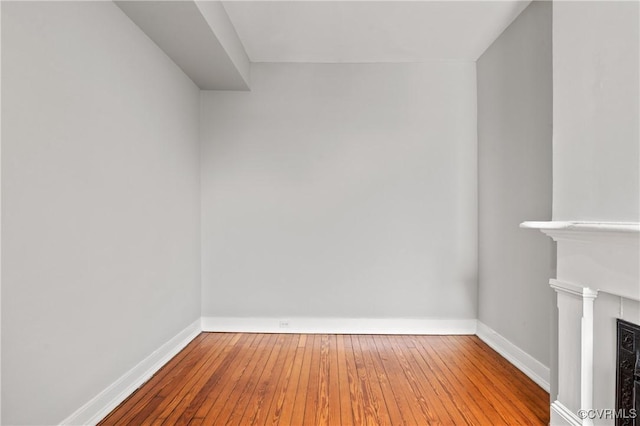 interior space with baseboards, hardwood / wood-style floors, and a fireplace