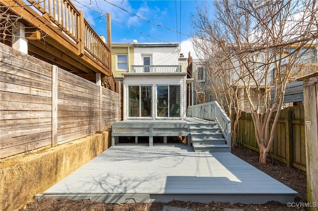 exterior space featuring a balcony, a deck, and fence