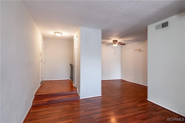 spare room with visible vents, a textured ceiling, ceiling fan, and wood finished floors