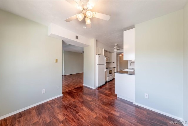 unfurnished living room with visible vents, ceiling fan, baseboards, and dark wood-style flooring