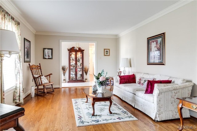 living room featuring crown molding, light wood-style flooring, and baseboards