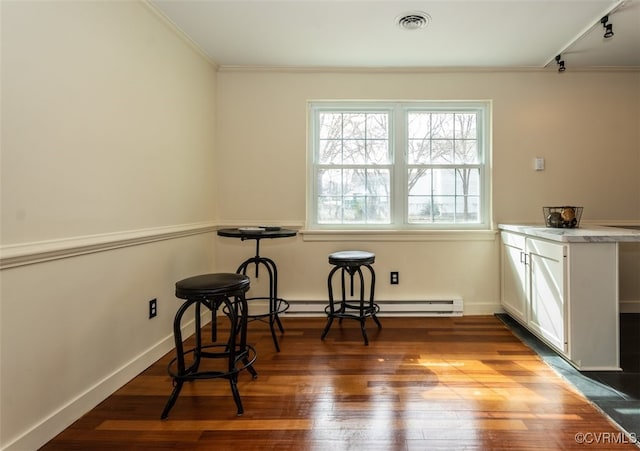 interior space with baseboards, visible vents, wood finished floors, and ornamental molding