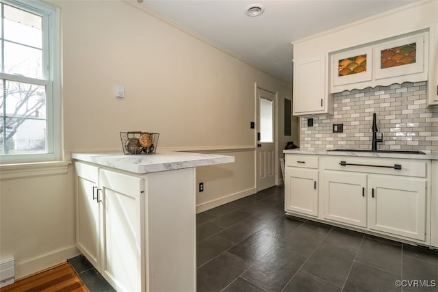 kitchen with white cabinets, a sink, and decorative backsplash