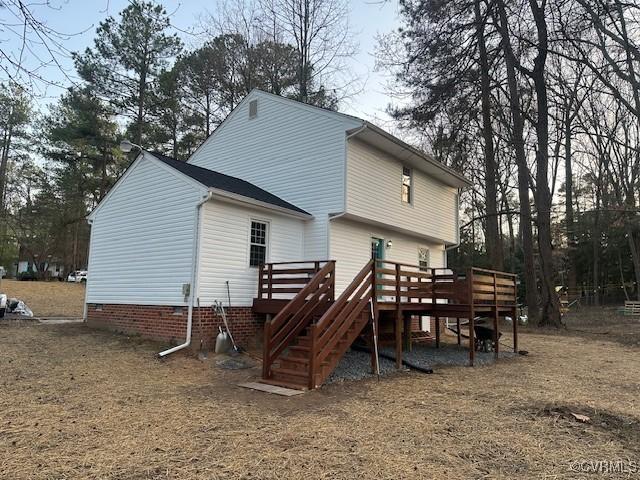 rear view of house featuring stairs, crawl space, and a wooden deck