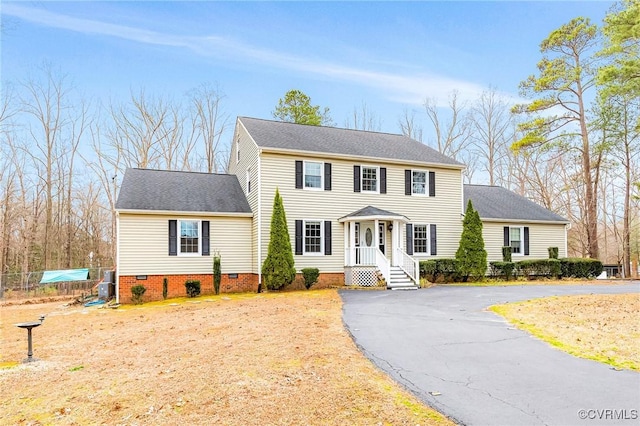 colonial-style house with aphalt driveway and crawl space