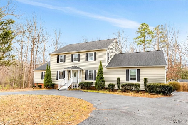 view of front of home with aphalt driveway and a shingled roof