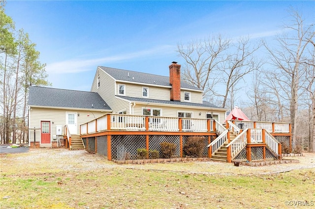 rear view of house with a chimney, stairway, and a deck