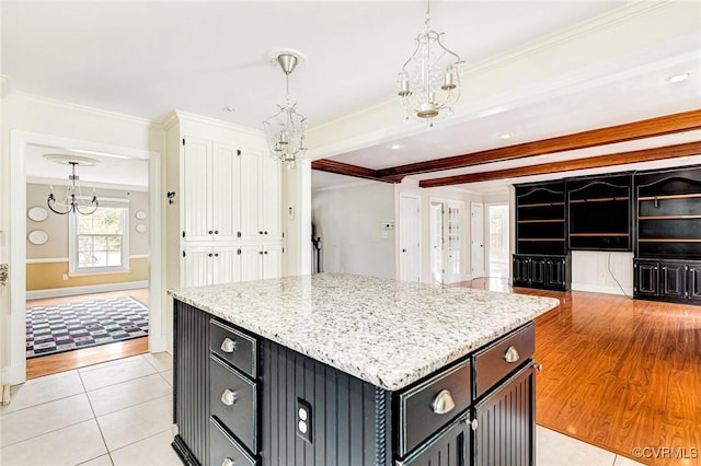 kitchen featuring a chandelier, a center island, pendant lighting, and crown molding