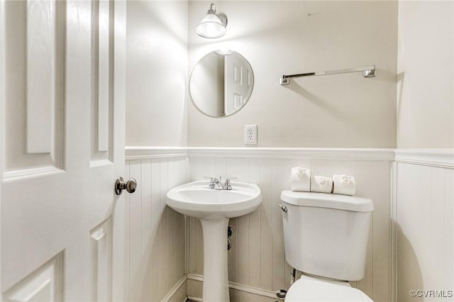 bathroom with wainscoting and toilet