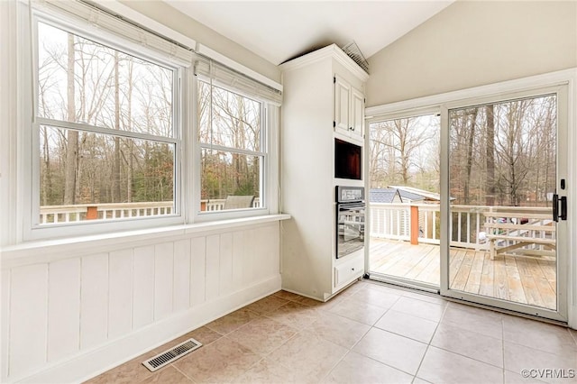 unfurnished sunroom featuring vaulted ceiling and visible vents