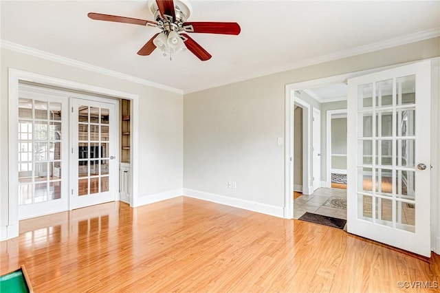 unfurnished room with baseboards, ornamental molding, wood finished floors, and french doors