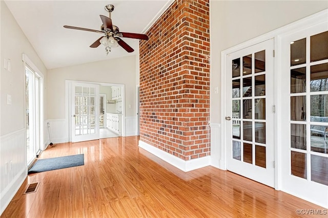 unfurnished sunroom featuring a ceiling fan, lofted ceiling, and visible vents