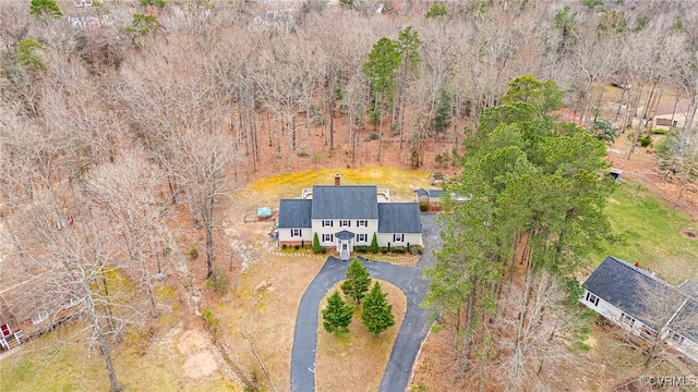 birds eye view of property featuring a forest view