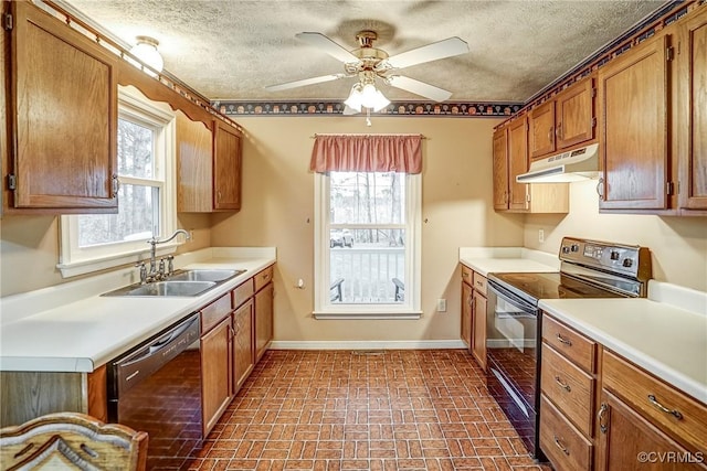 kitchen featuring baseboards, under cabinet range hood, light countertops, black appliances, and a sink