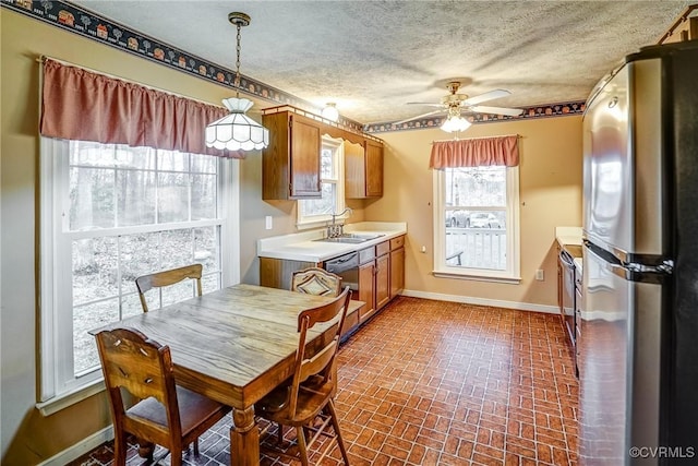 dining room with brick floor, a textured ceiling, baseboards, and a ceiling fan