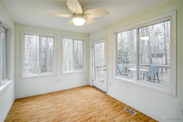 unfurnished sunroom featuring ceiling fan and visible vents