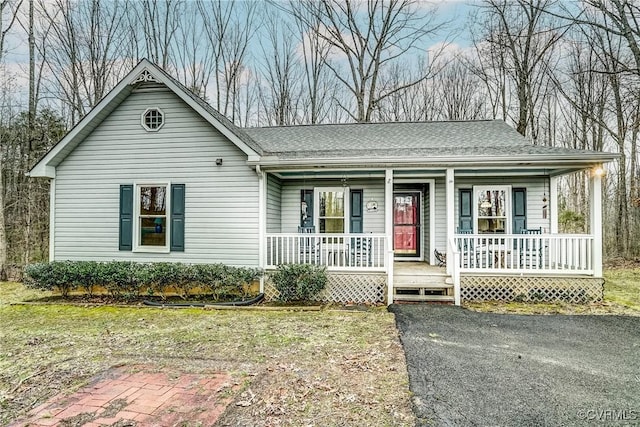 ranch-style house with a shingled roof and a porch