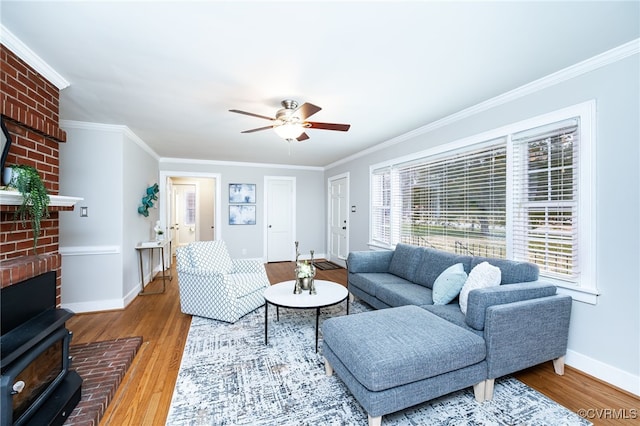 living area with baseboards, ceiling fan, ornamental molding, and wood finished floors