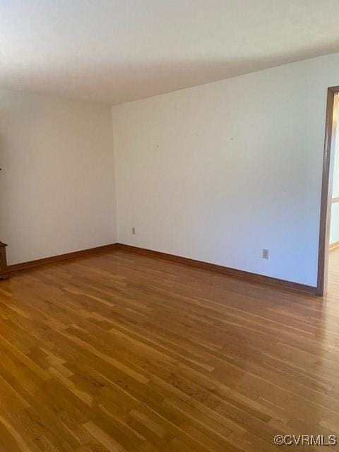 spare room with wood finished floors and baseboards