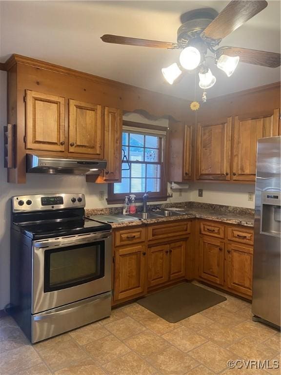 kitchen with appliances with stainless steel finishes, brown cabinetry, a sink, and under cabinet range hood