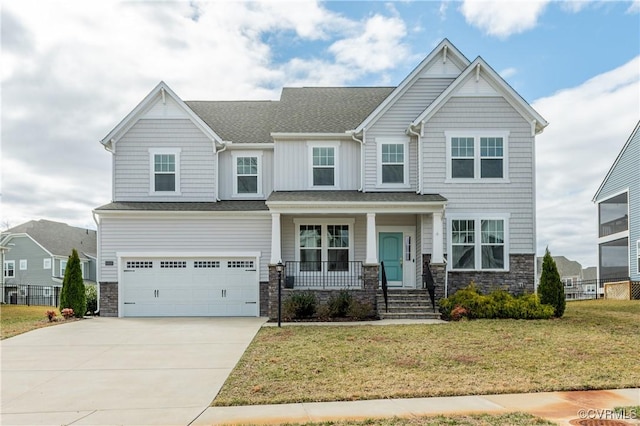 craftsman-style house with a garage, concrete driveway, stone siding, a porch, and a front lawn