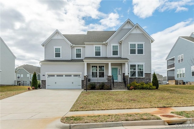 craftsman-style home featuring concrete driveway, stone siding, an attached garage, covered porch, and a front lawn