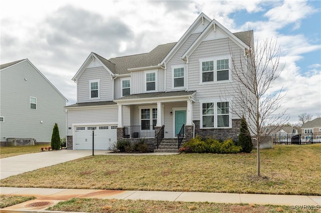 craftsman inspired home with covered porch, a garage, driveway, stone siding, and a front yard