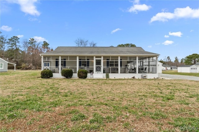 back of house with a yard and a sunroom