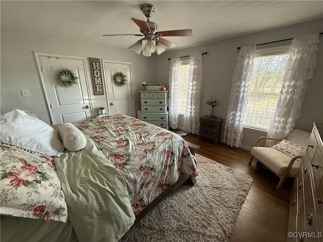 bedroom featuring wood finished floors, two closets, and ceiling fan