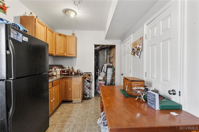 kitchen with dark countertops, light tile patterned floors, water heater, and freestanding refrigerator