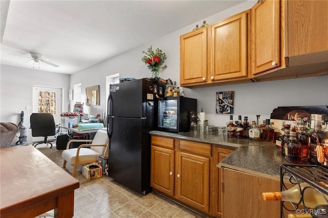 kitchen with dark countertops, open floor plan, brown cabinets, freestanding refrigerator, and a ceiling fan