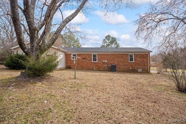 back of property featuring crawl space, cooling unit, and brick siding