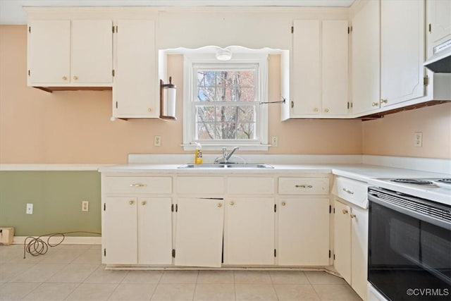 kitchen with electric stove, light countertops, light tile patterned flooring, a sink, and under cabinet range hood