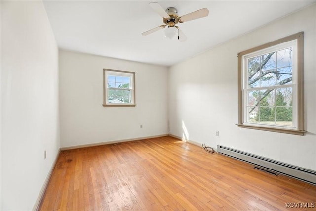 unfurnished room with baseboards, a baseboard heating unit, a ceiling fan, and light wood-style floors
