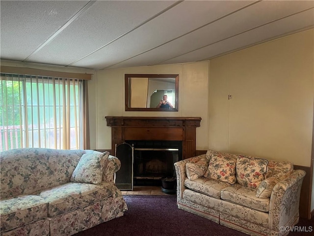living room featuring carpet, a textured ceiling, and a fireplace