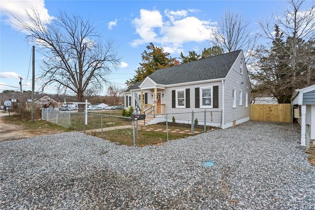 bungalow-style house featuring a shingled roof and a fenced front yard