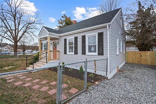 bungalow featuring a gate, roof with shingles, fence, and a chimney