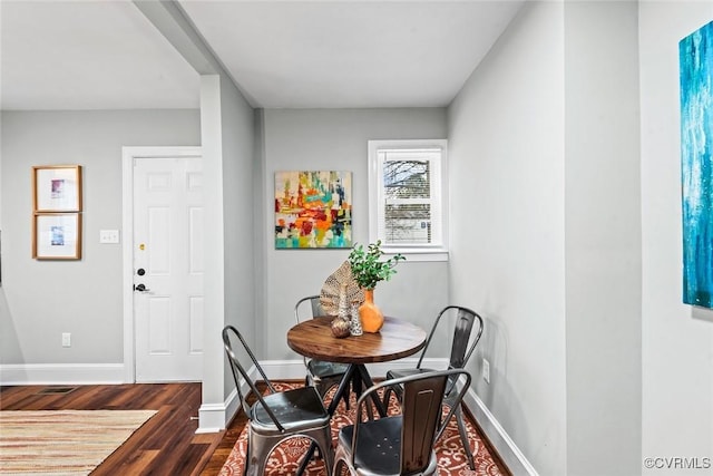 dining space with dark wood-style floors and baseboards