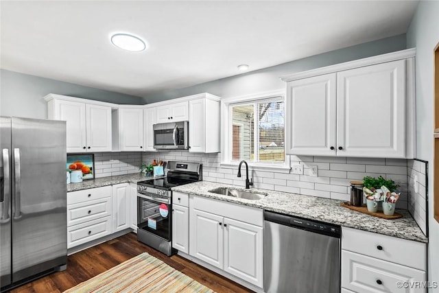 kitchen featuring stainless steel appliances, dark wood finished floors, white cabinets, and a sink