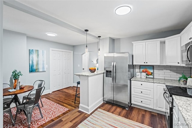 kitchen with dark wood-type flooring, white cabinetry, appliances with stainless steel finishes, backsplash, and decorative light fixtures