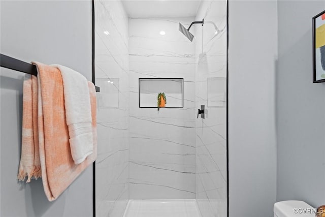 full bathroom with a marble finish shower and toilet