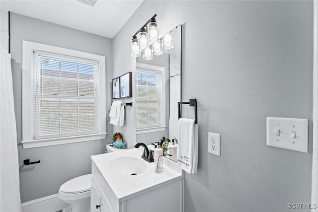 full bath featuring toilet, visible vents, vanity, and baseboards