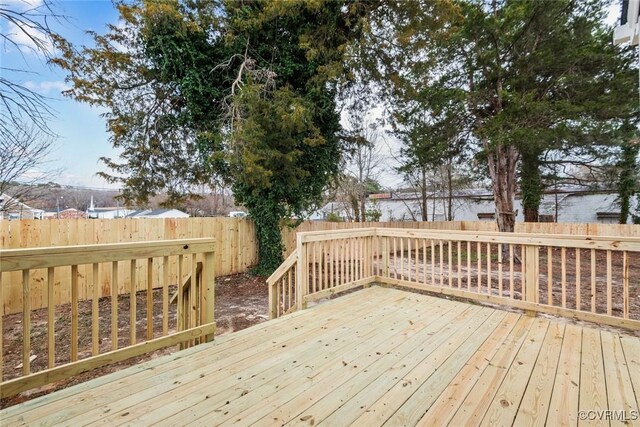 wooden terrace with a fenced backyard