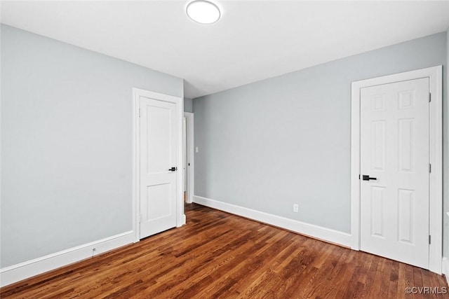 unfurnished bedroom with baseboards and wood finished floors