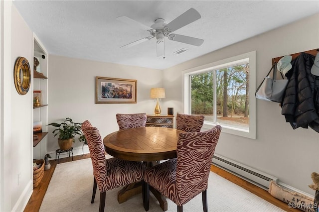 285 Ferry Landing Rd, Dunnsville, VA 22454 - dining space featuring a baseboard heating unit, wood finished floors, a ceiling fan, and baseboards
