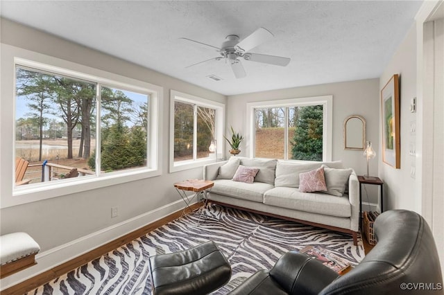 285 Ferry Landing Rd, Dunnsville, VA 22454 - living room featuring healthy amount of natural light, baseboards, wood finished floors, ceiling fan, and a textured ceiling
