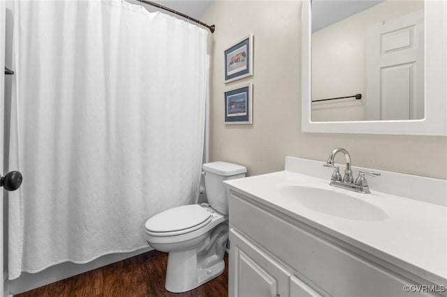 bathroom with toilet, a shower with shower curtain, wood finished floors, and vanity