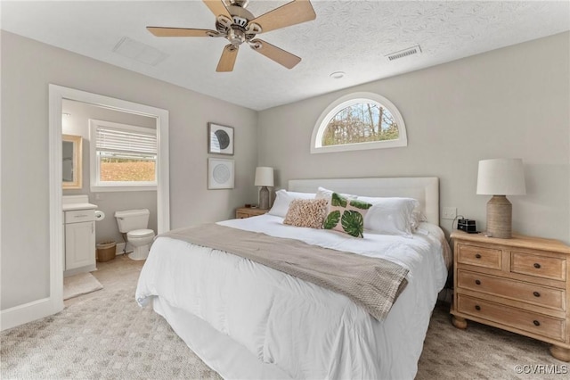 285 Ferry Landing Rd, Dunnsville, VA 22454 - bedroom with multiple windows, light carpet, connected bathroom, and ceiling fan