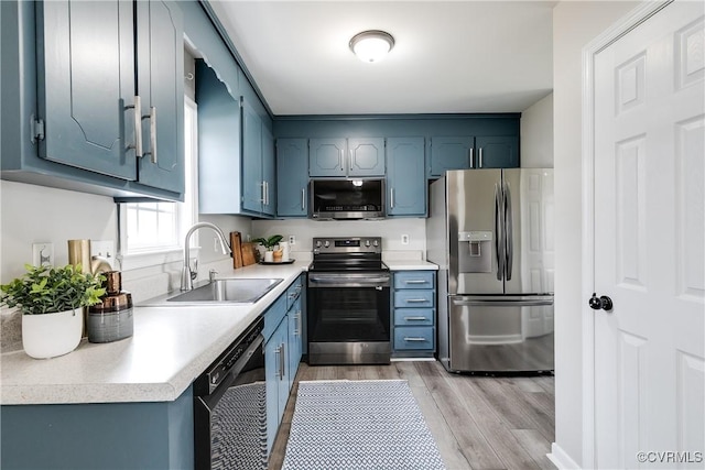 kitchen featuring a sink, light countertops, light wood-style floors, and stainless steel appliances