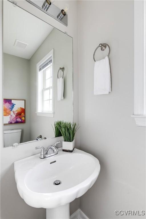 bathroom featuring a sink, visible vents, and toilet